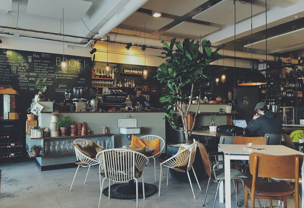 Café counter with espresso machine and barista at work
